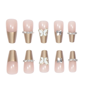 Coffin press-on nails with butterfly charms, pink french tips, and rhinestone chains