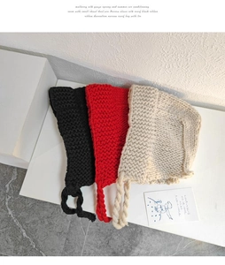 Gros plan de trois bonnets d'hiver en tricot avec de longs liens tressés, noir, rouge et beige