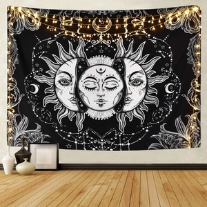 Detail view of bohemian moon phase tapestry with sun and mystical patterns on a black wall