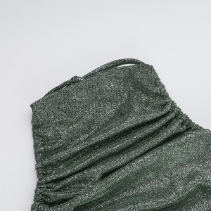 Close-up of emerald green lurex fabric with metallic shimmer and elegant pleated texture