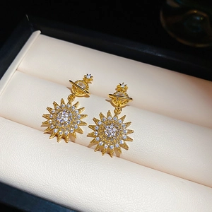 Close-up of gold starburst earrings with sparkling cubic zirconia in a jewelry box