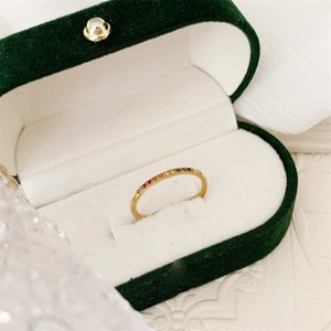 Detailopname van 18k vergulde regenboog edelsteen ring in een groene fluwelen juwelendoos
