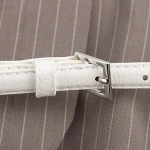 White crocodile pattern waist belt with silver buckle on striped vest for women