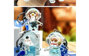 Close-up of blue astronaut quicksand keychains with floating figures and metal rings