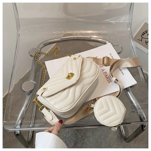 White quilted crossbody bag with adjustable wide strap, gold chain, and round pouch