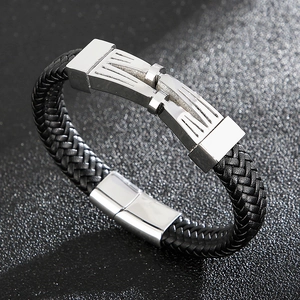 Détail d'un bracelet en cuir tressé noir avec fermoir magnétique en acier sur fond gris