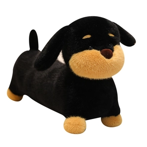 Soft dachshund plush dog toy in black and tan colors, side view on white background