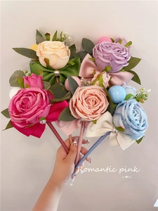 Detail view of five assorted artificial rose pens featuring silk petals and satin bows