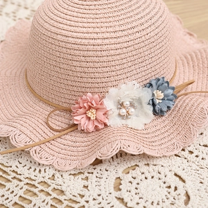 Cappello da sole in paglia rosa per bambina con tre fiori e tesa ondulata per la spiaggia