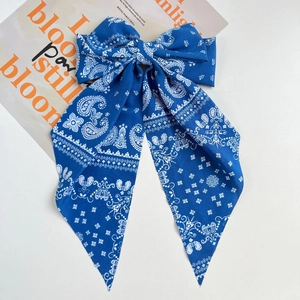 Detail of navy blue paisley print bow hair clip with long elegant flowing ribbons