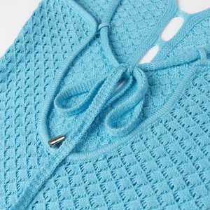 Détail de la robe crochet bleu ciel avec maille ajourée et cordon à embouts métalliques