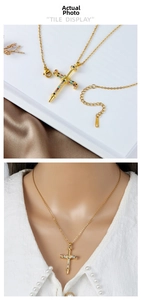 Detail of gold cross pendant necklace with colorful cubic zirconia on a silk background
