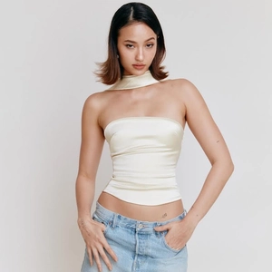Detail van de crèmekleurige satijnen tube top met bijpassende sjaal en glanzende stof