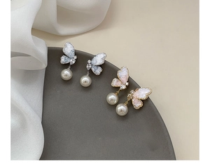 Macro view of gradient butterfly earrings with faux pearls and sparkling crystals