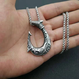 Silver stainless steel viking fish hook pendant necklace shown on a hand palm