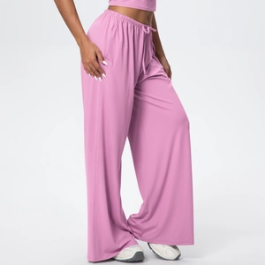 Detail of pink wide-leg sports trousers showing elastic drawstring waist and side pockets