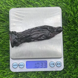 Detailed view of hand-carved Virgin Mary statue weighing 103.3g on a scale