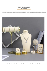 Detail of beige velvet and gold metal jewelry stands for necklaces and rings