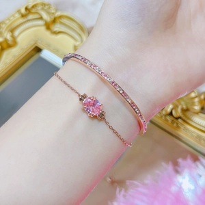 Detail of rose gold bracelet and bangle set with pink crystals on a female wrist