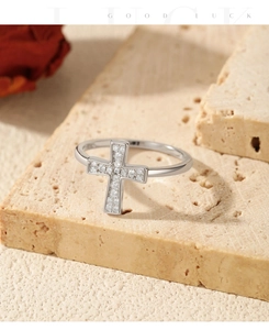 Macro shot of silver cross ring with pavé moissanite stones on a stone pedestal