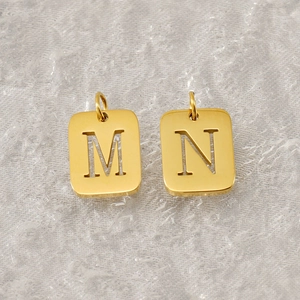 Detailed view of square hollow letter M and N gold titanium steel jewelry pendants