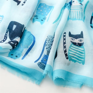 Close-up of soft light blue scarf featuring cute cat prints and delicate fringe edges