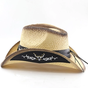 Détail d'un chapeau de cow-boy en paille avec broderie vintage et rivets métalliques