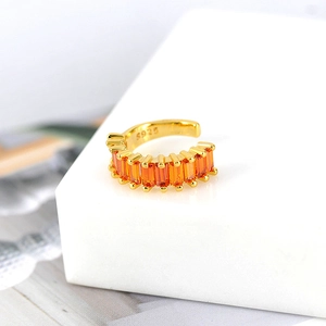 Macro shot of S925 engraved gold plated ear cuff with orange rectangular zircons