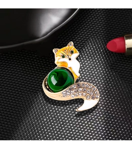 Macro shot of fox brooch with green gemstone body and sparkling crystal accents