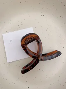 Détail macro d'une pince à cheveux ambre en résine avec motif écaille de tortue