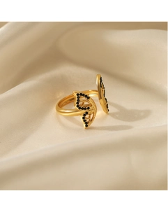 Detailed view of an adjustable gold-plated butterfly ring with black stones on silk