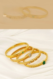 Vue détaillée de quatre bracelets joncs en acier inoxydable doré sertis de cristaux