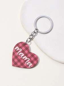 Detail of mama heart keychain with pink plaid pattern on white stone surface