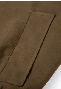 Macro detail of the diagonal flap pocket on a heavy wool blend dark brown retro jacket