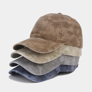 Close-up of four washed cotton baseball caps in brown, beige, grey, and navy blue