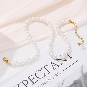 Detailed macro view of elegant pearl necklace with gold clasp on minimalist fabric