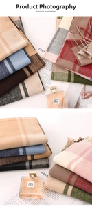 Close-up of thick cashmere-feel plaid scarves with long tassels in various colors