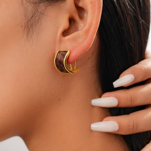 Close-up of vintage C-shaped leopard print earrings with gold metal base on model