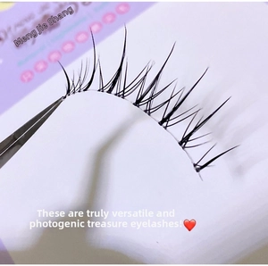 Detailed macro shot of natural 3D false eyelashes with thin clear band and tweezers