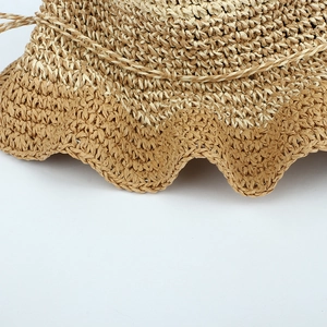 Detail of color-block handmade crochet straw hat with wavy brim and woven drawstring