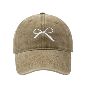 Détail de la broderie de nœud blanc sur une casquette de baseball en coton kaki