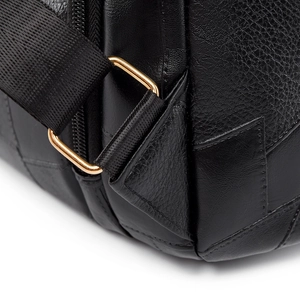 Detail of lychee pattern leather with gold metal buckle and nylon strap on black backpack