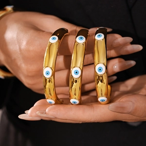 Three-piece set of gold titanium steel bracelets featuring blue evil eye charms for women