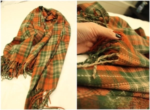 Detail of plaid scarf featuring orange and green checks with long braided tassels