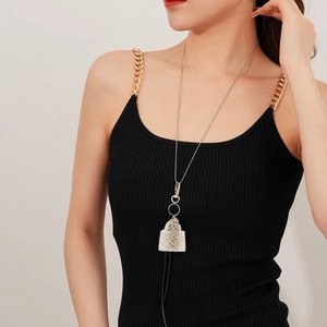 Détail d'un collier pendentif sac à main argenté avec pompons et strass sur mannequin
