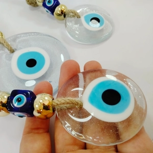 Detailed view of Evil Eye glass pendants with golden beads and rustic jute rope