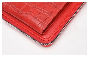 Close-up of red crocodile embossed texture and premium stitching on a slim crossbody bag