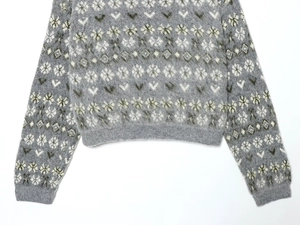 Detail of gray floral jacquard knit sweater with soft fuzzy texture and ribbed cuffs