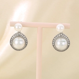 Détail de boucles d'oreilles françaises en acier inoxydable avec perles et strass