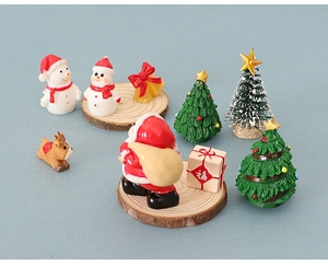 Miniature resin Christmas figurine set featuring Santa, Reindeer and Xmas trees on wood